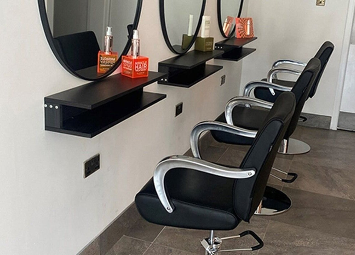 Modern salon chairs and mirrors at Ego Hairdressing in Milngavie, Scotland, GB offer a sleek, professional setup.