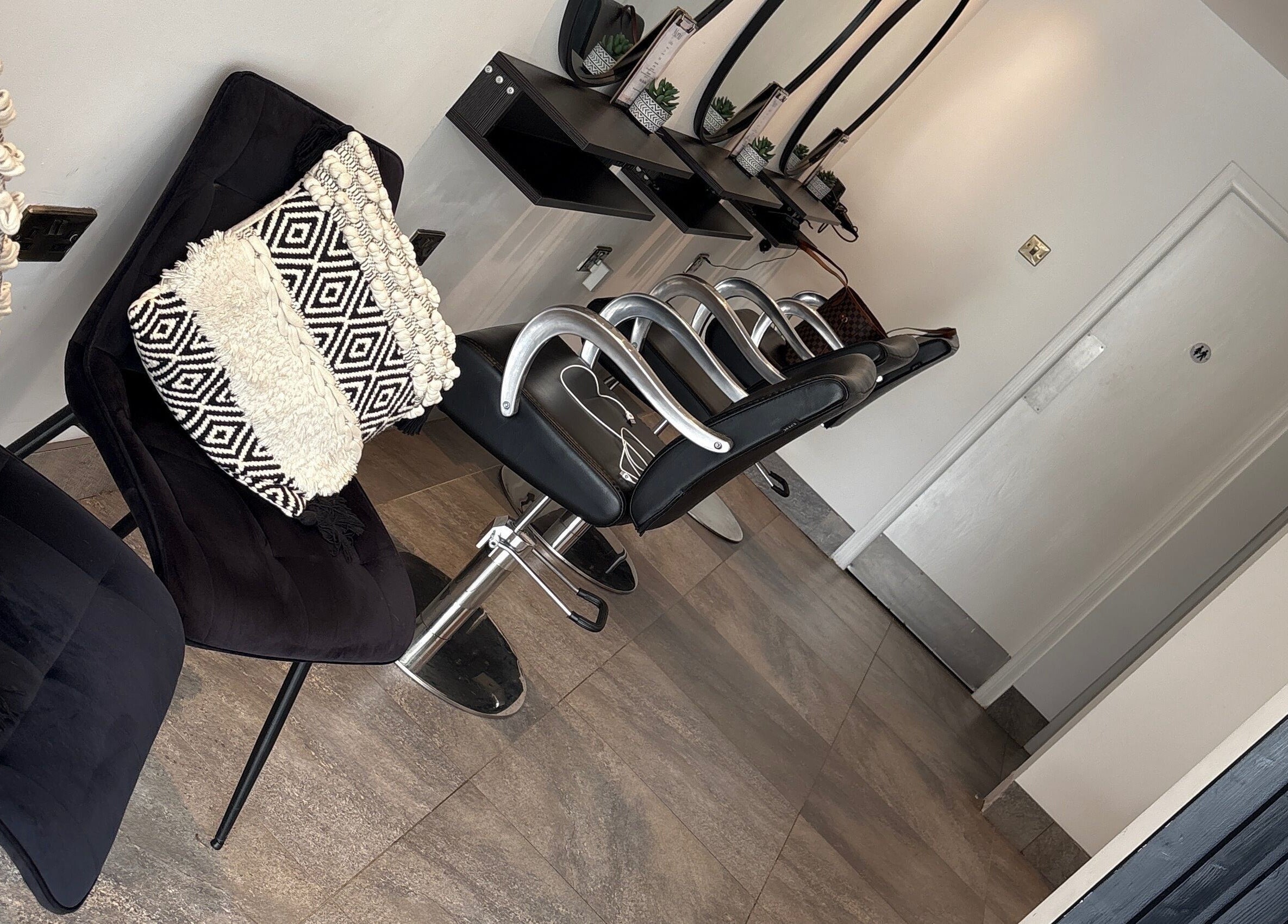 Modern salon seating area at Ego Hairdressing in Milngavie, Scotland, GB, showcasing stylish chairs and decor.