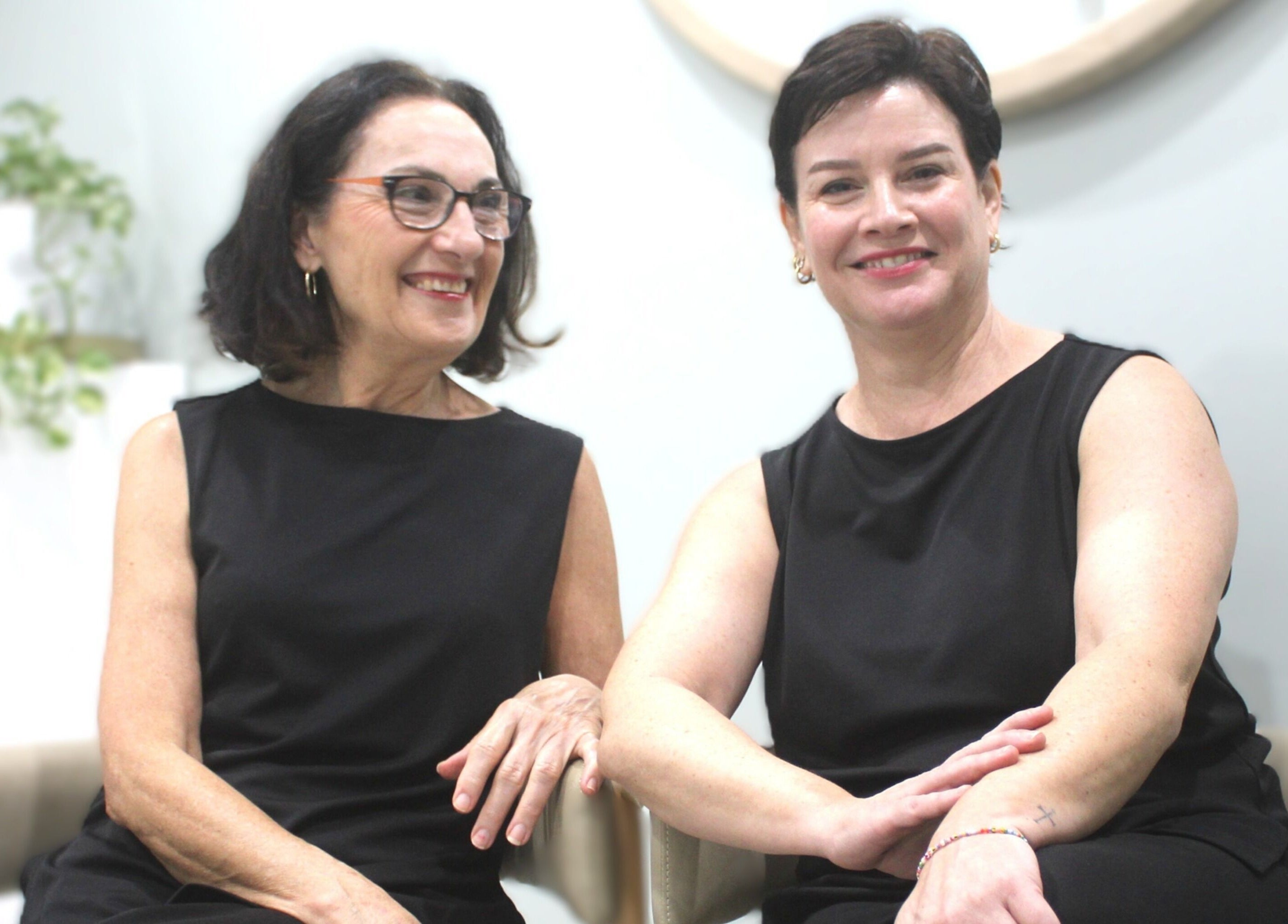 Two smiling women sitting at Beauty on Main, Main Beach, Queensland, AU.