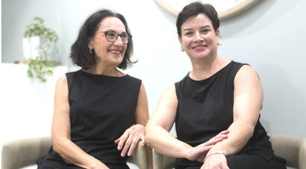 Two smiling women sitting at Beauty on Main, Main Beach, Queensland, AU.