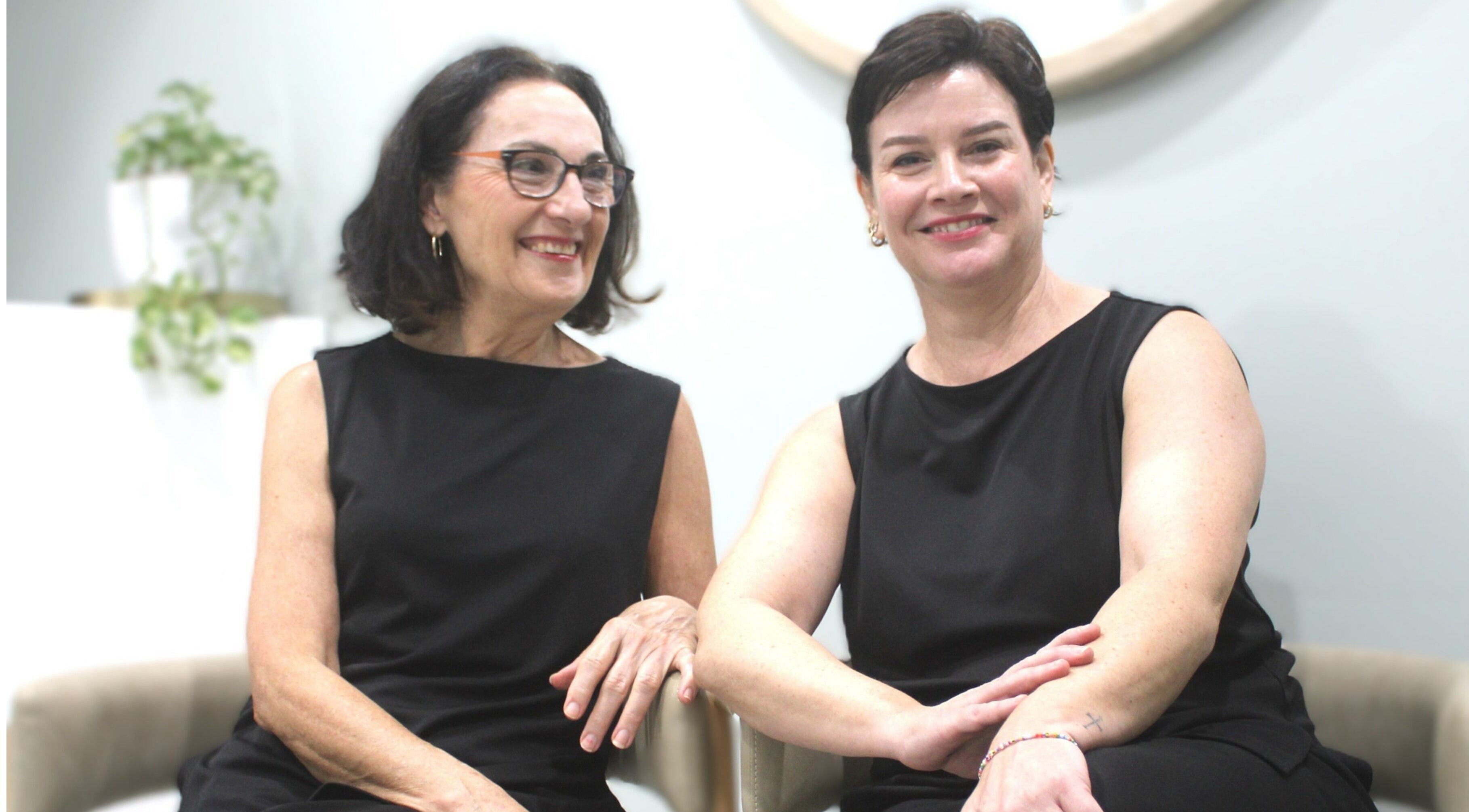 Two smiling women sitting at Beauty on Main, Main Beach, Queensland, AU.