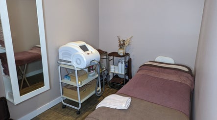 JH Beauty Lounge cozy treatment room in Neutral Bay, New South Wales, AU, featuring a massage bed and equipment.