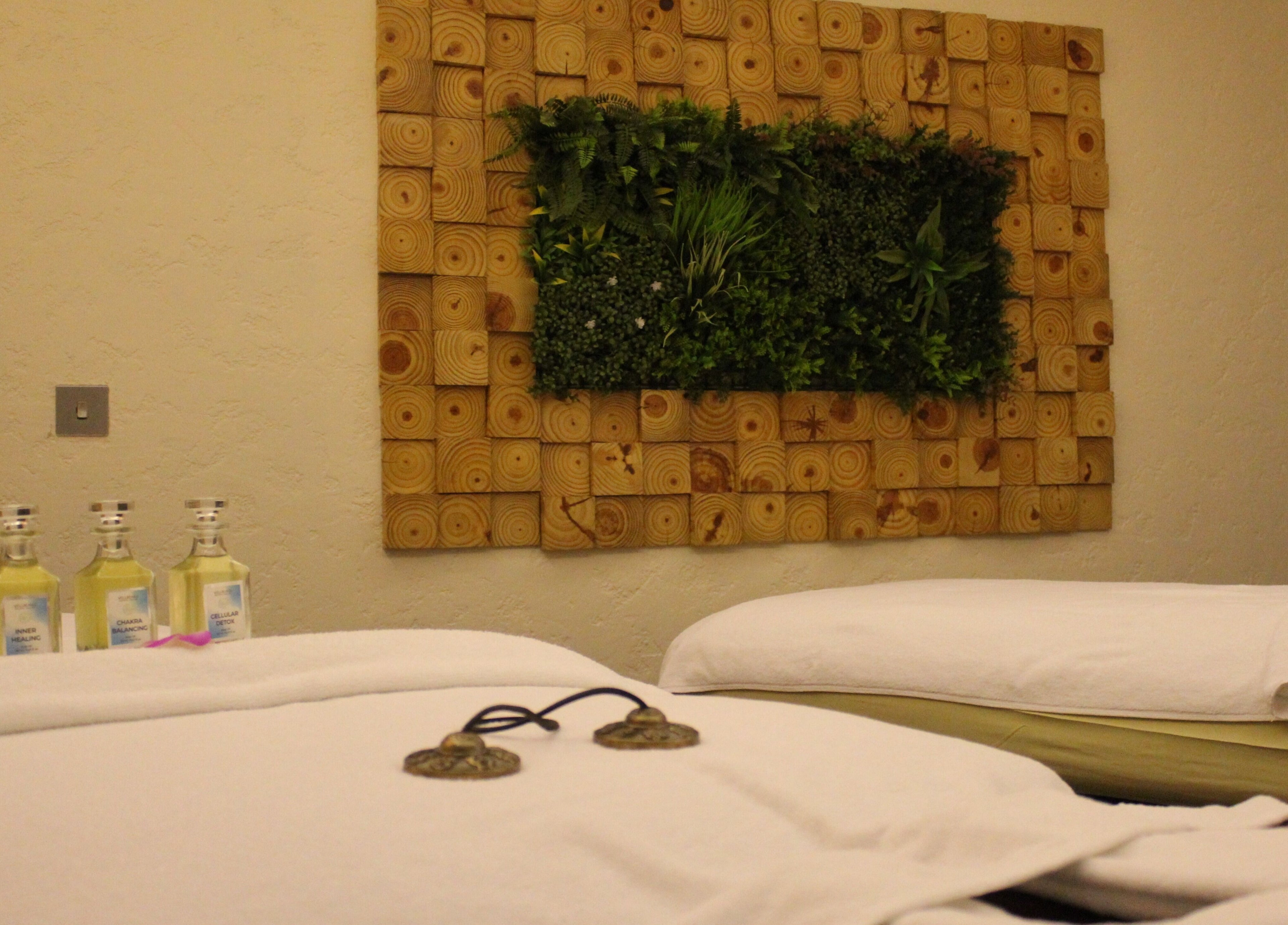 Massage room with oils and green wall at Wellbeings Holistic Healing - Fairmont, Dubai. Relax in Dubai, AE.