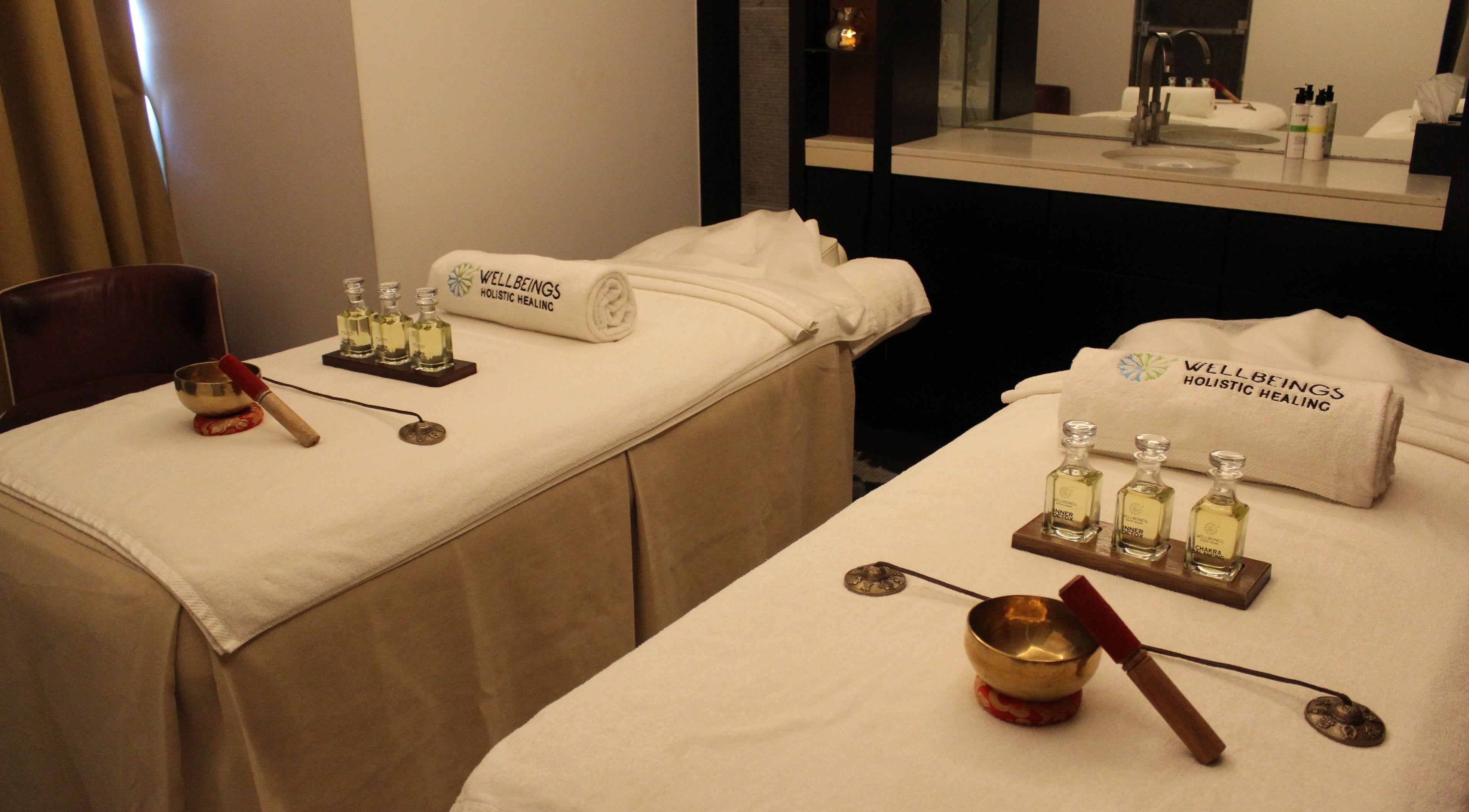 Tranquil treatment room at Wellbeings Holistic Healing, Dubai, AE, featuring massage tables and essential oils.