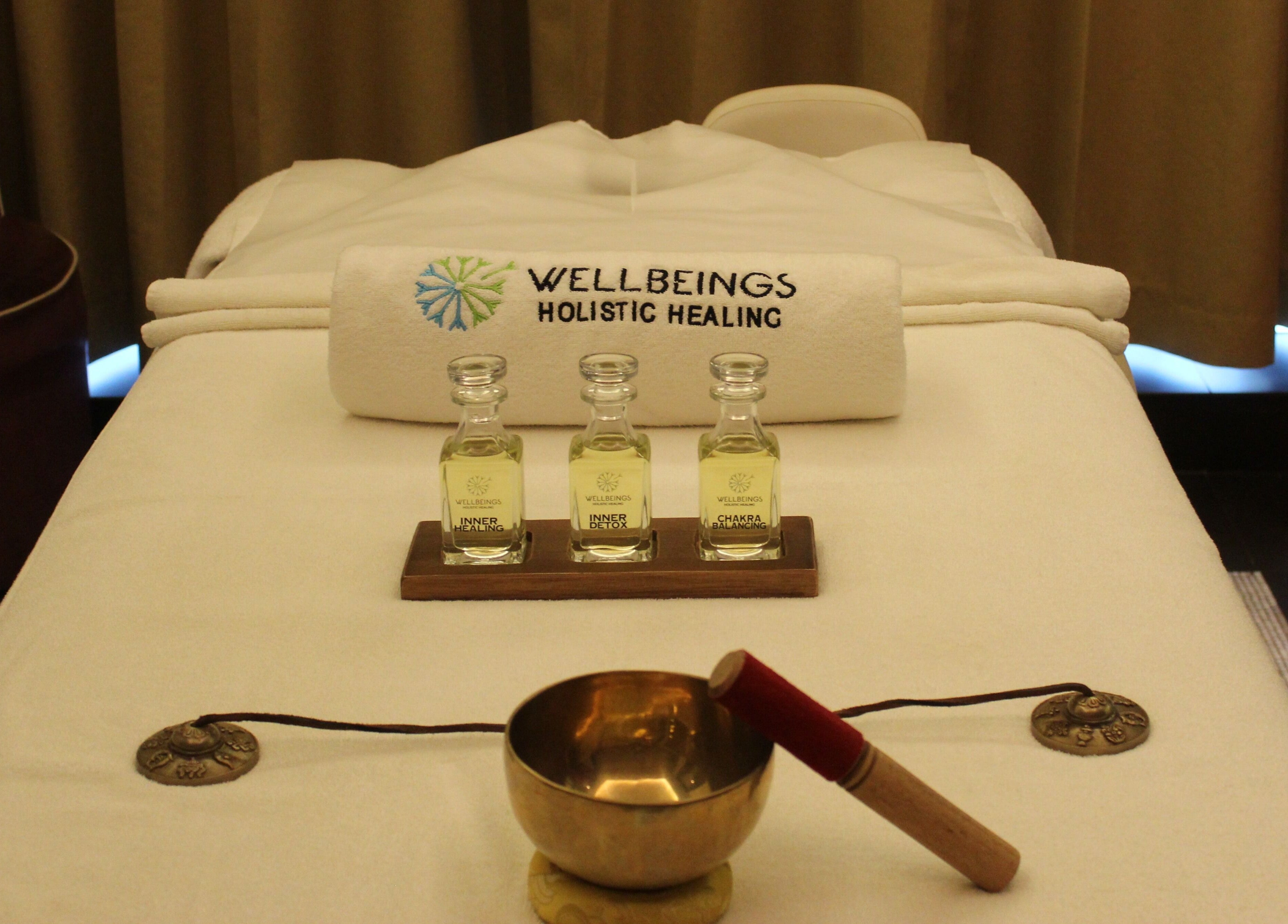Massage table setup at Wellbeings Holistic Healing in Dubai, AE with oils and a sound bowl.