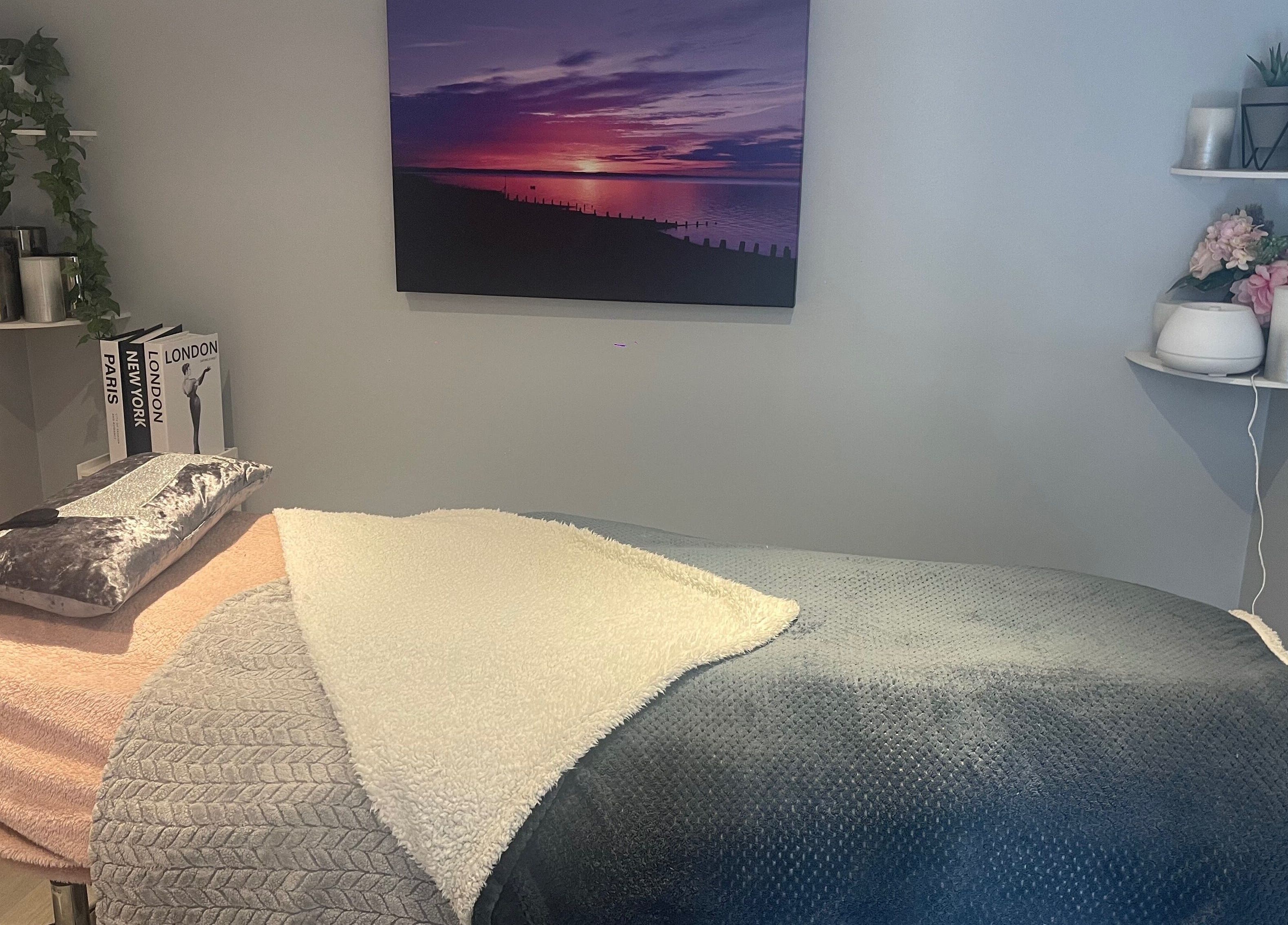 Relaxing therapy room at MedicAesthetics, Oakley, England, GB with cozy blankets and calming decor.