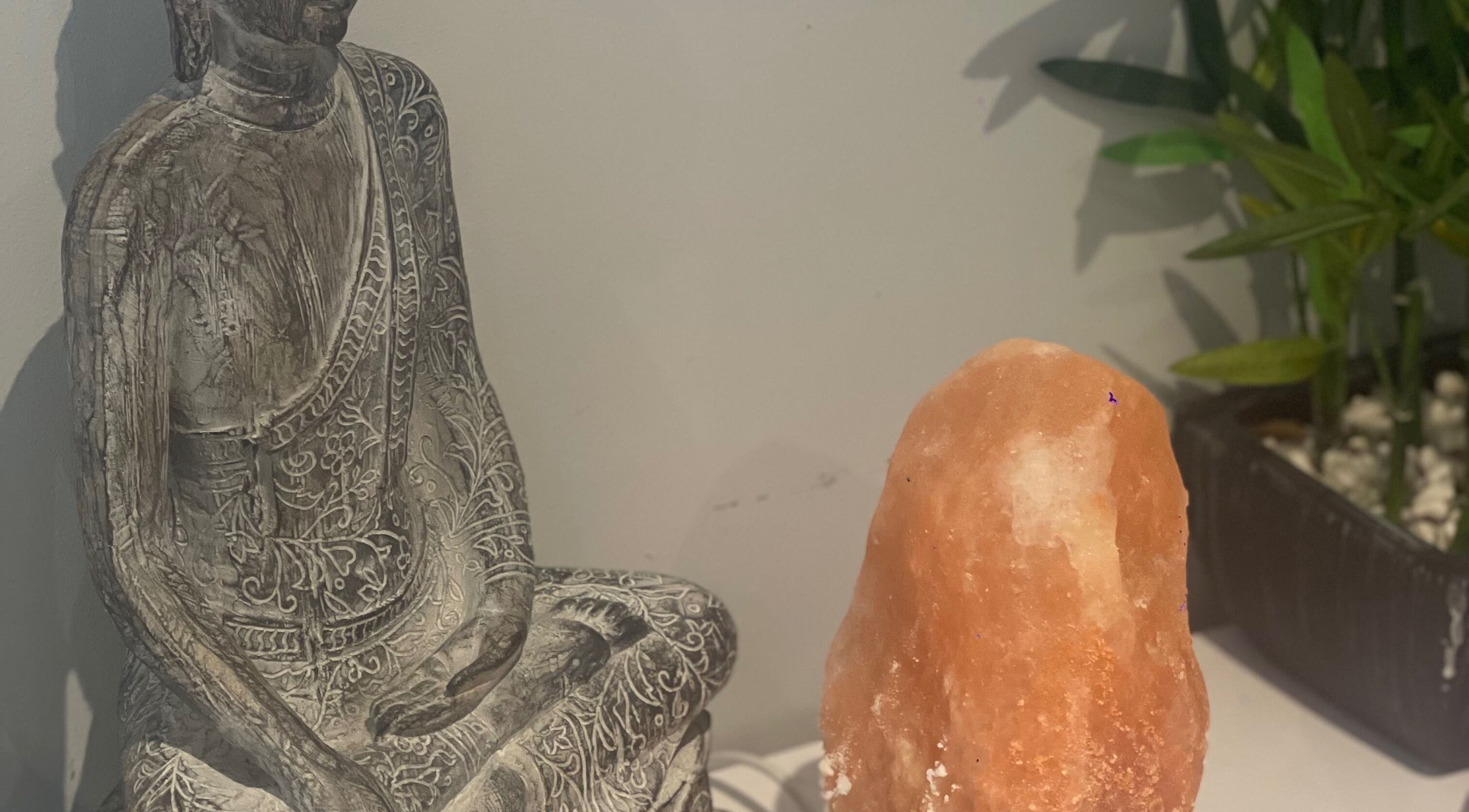 Buddha statue with Himalayan salt lamp at MedicAesthetics, Oakley, England, GB.