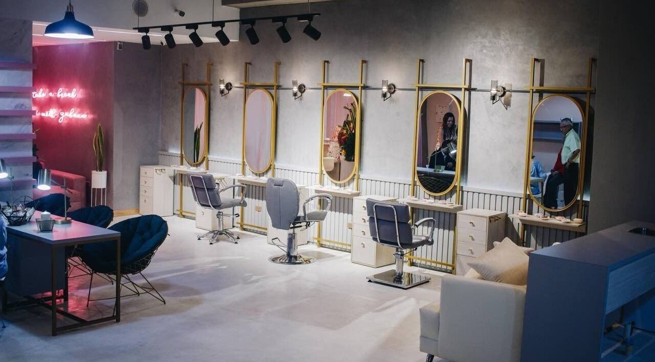 Interior moderno de Gabana Beauty en Valencia, Carabobo, VE, con espejos dorados y sillas elegantes.