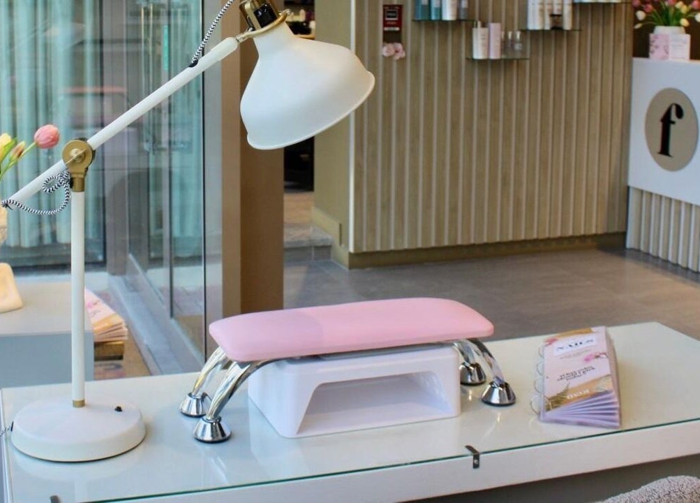 Elegant nail station at Freya Beauty Salon JVC, Dubai, Dubai, AE with modern lamp and decor.