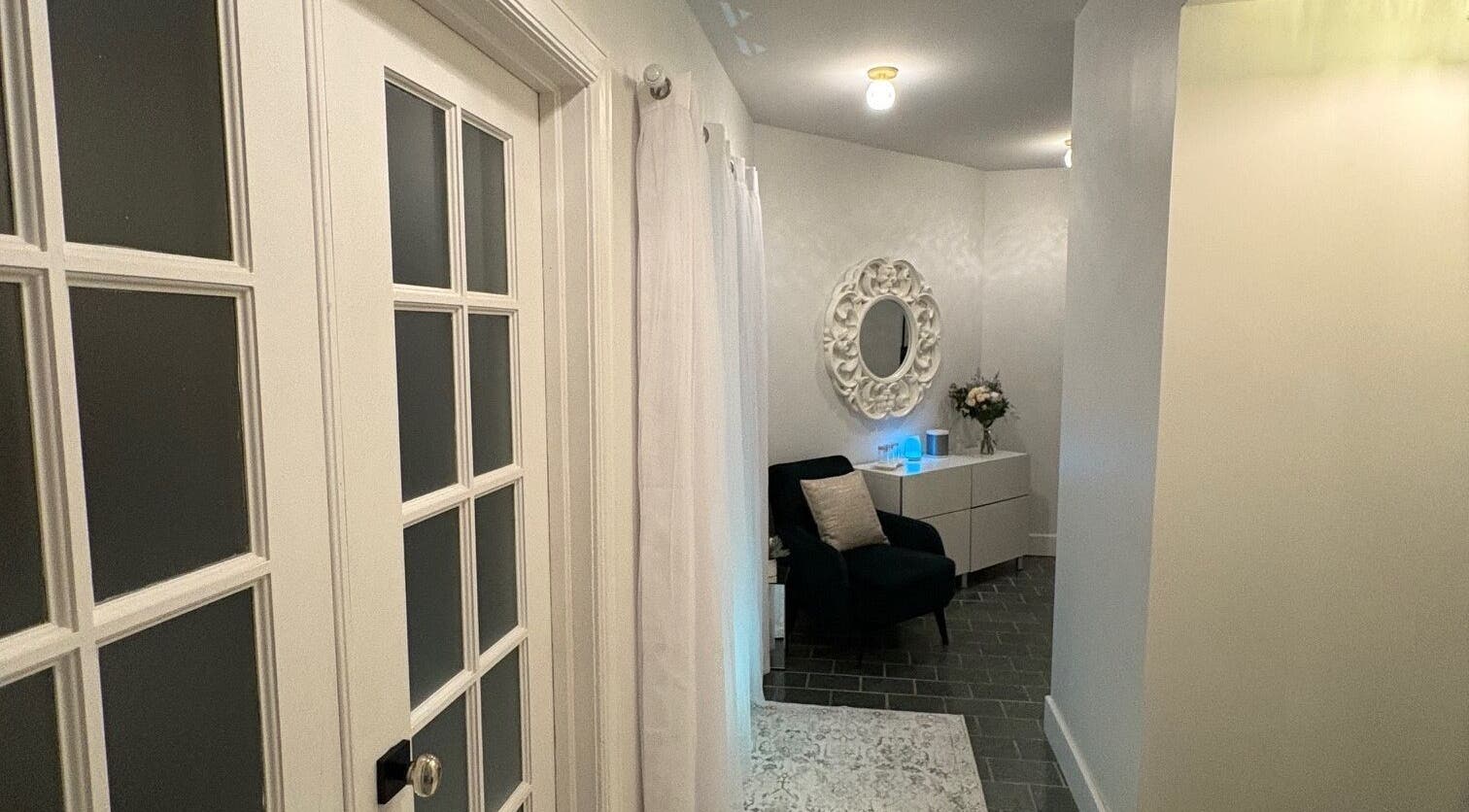 Entrée apaisante de Clinique Éternité Outremont, Montréal, Québec, CA, avec fauteuil et miroir élégant.