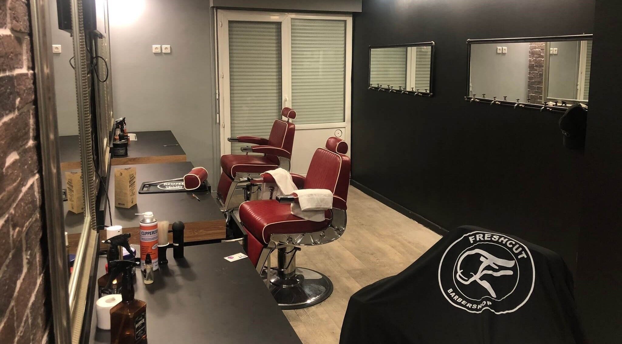 Intérieur moderne du salon Freshcut Épinay à Épinay-sous-Sénart, Île-de-France avec chaises coiffure rouges.