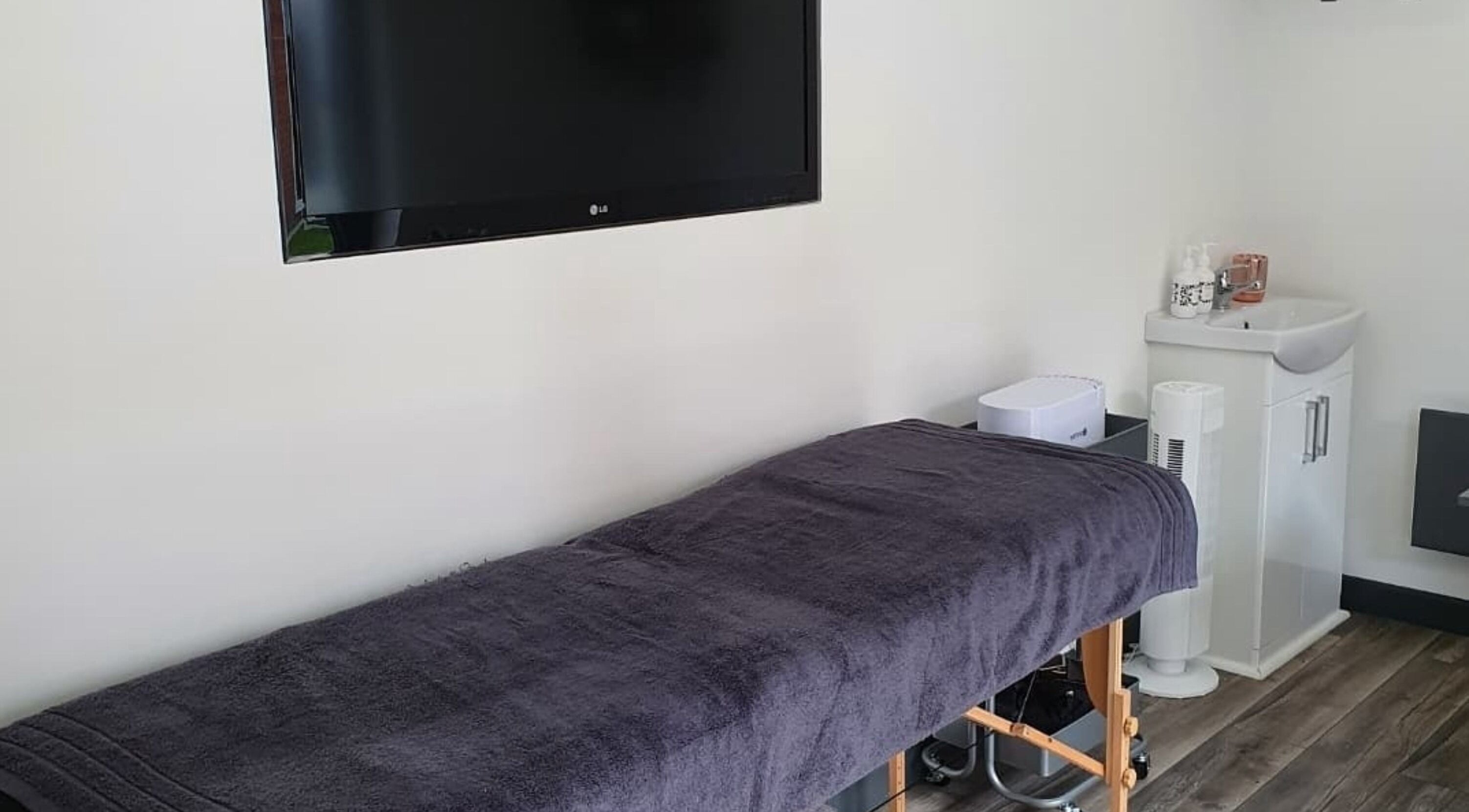 Relaxing therapy room at No.33 beauty, Welton, Lincoln, Welton, England, GB with treatment bed and TV.