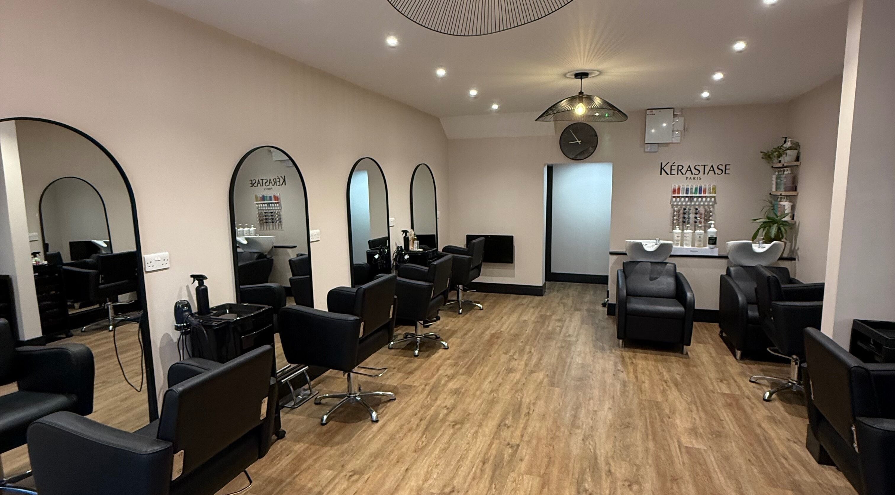 Stylish interior of The Hair Studio Southsea in Portsmouth, England, GB, featuring modern black chairs and sleek decor.
