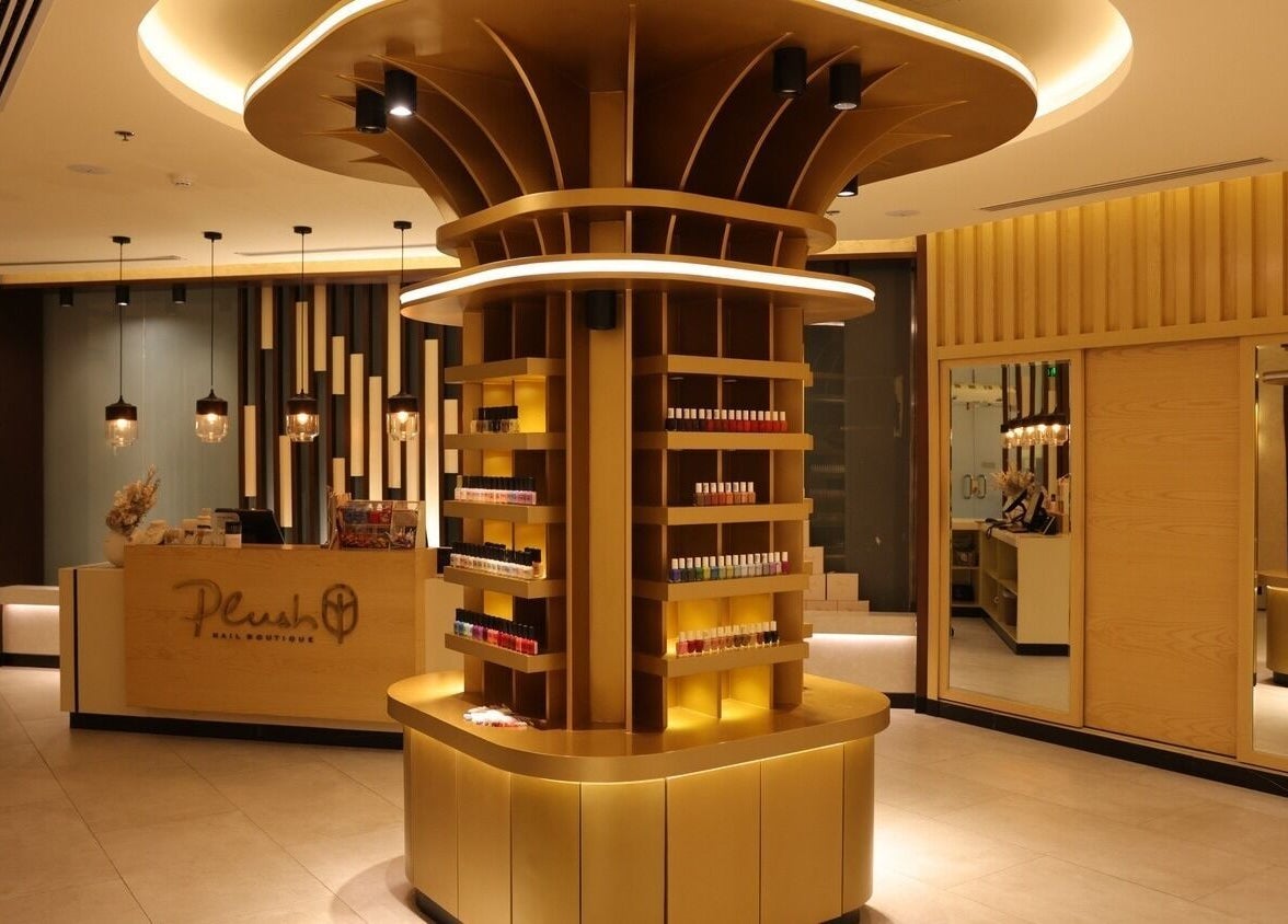 Elegant interior of Plush Nail Boutique - Al Mutamarat, showcasing nail polish displays and modern decor in Riyadh, SA.