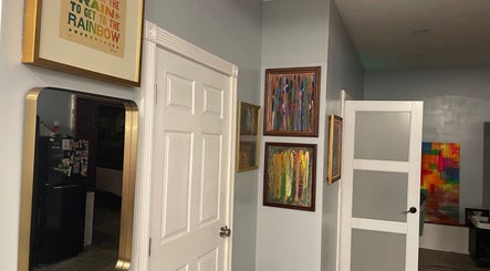 Art-filled hallway at Elevate Wellness - Allison Best, LMT in Belpre, Ohio, US showcasing colorful framed artworks.