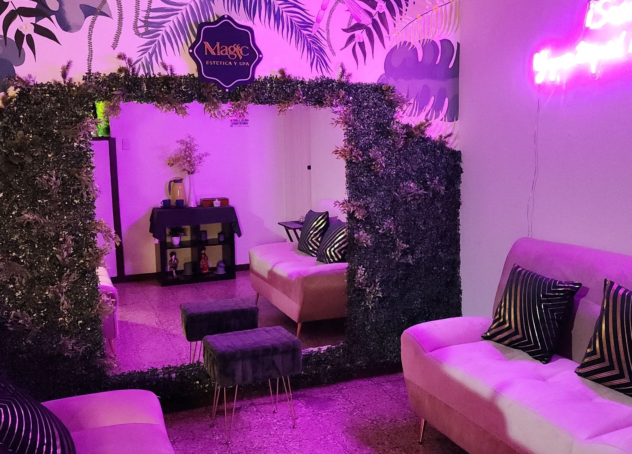 Relajante sala iluminada de Magic Estética y Spa en San José, San José, CR con sofás y decoración tropical.