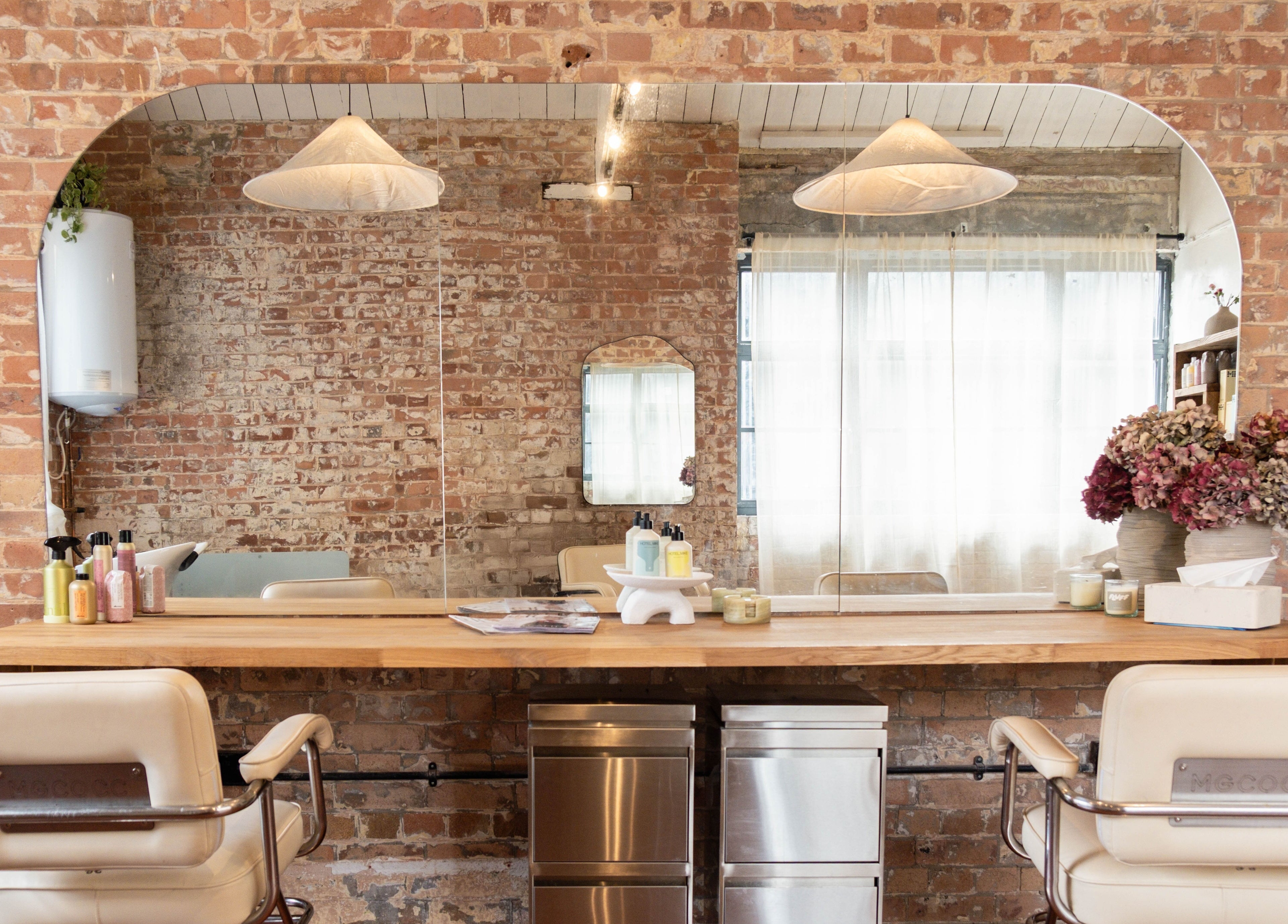 Fluff.Hackney salon in London, England, GB features rustic brick walls and modern styling chairs.