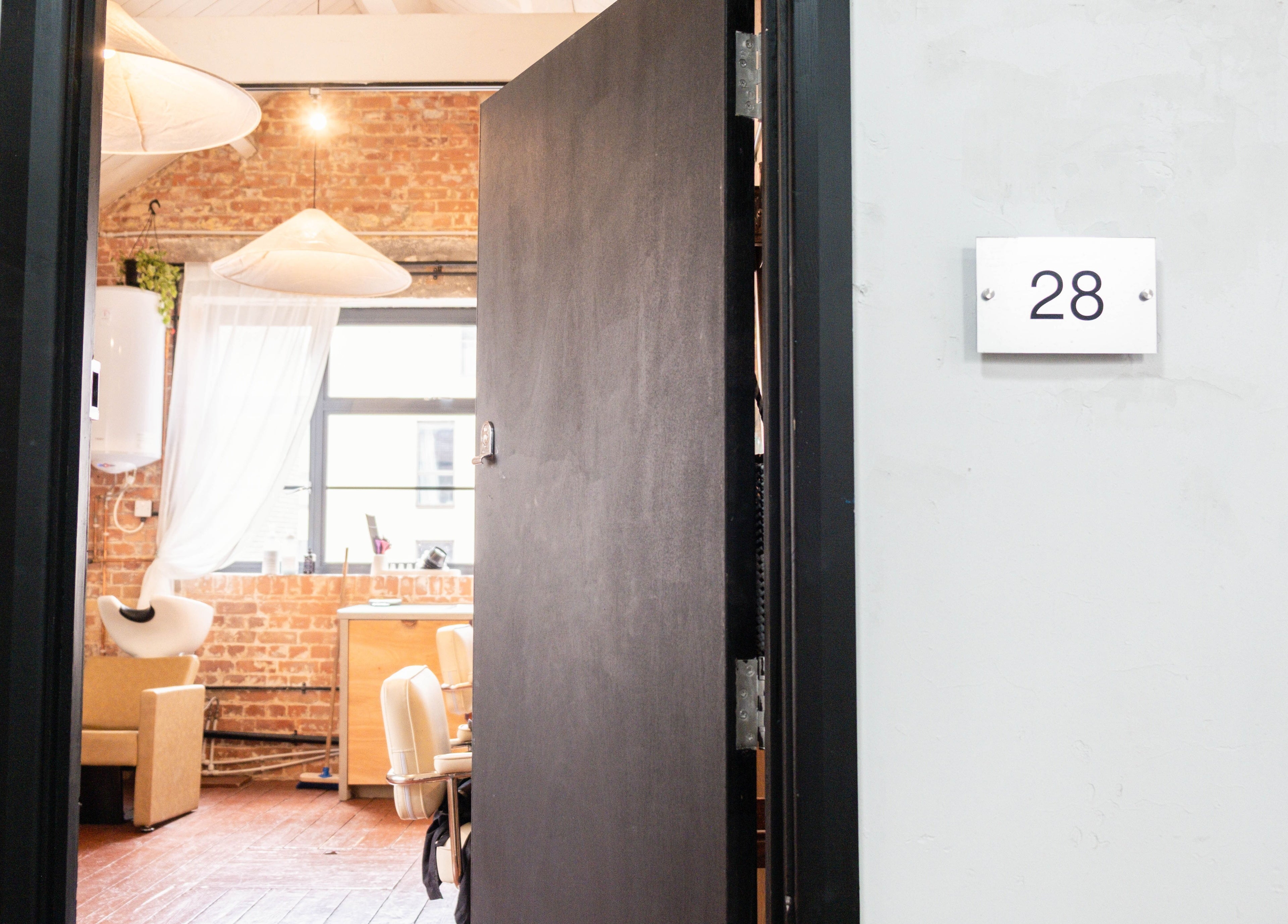 Open door to Fluff.Hackney salon reveals inviting interior, vibrant decor in London, England, GB.