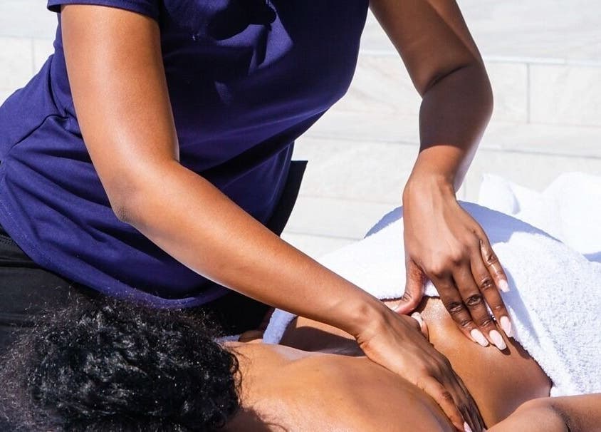 Therapist at Emihle Wellness & Mobile Spa in Berea, Kwazulu-natal, ZA performing a relaxing massage outdoors.