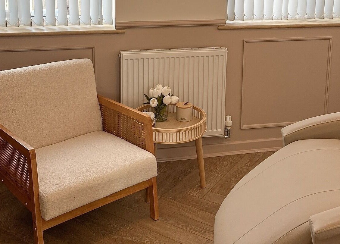 Relaxing seating area at Jade Carla Beauty, Southport, England, GB. Cozy chair and table with flowers.