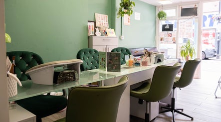 Chic nail station at Beautique Salon, London, England, GB, with elegant green chairs and welcoming decor.
