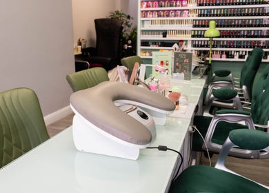 Nail care station at Beautique Salon in London, England, GB showcasing elegant green chairs and manicure tools.