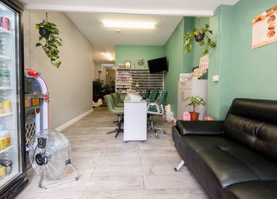 Chic interior of Beautique Salon in London, England, GB, featuring sleek chairs and vibrant decor.