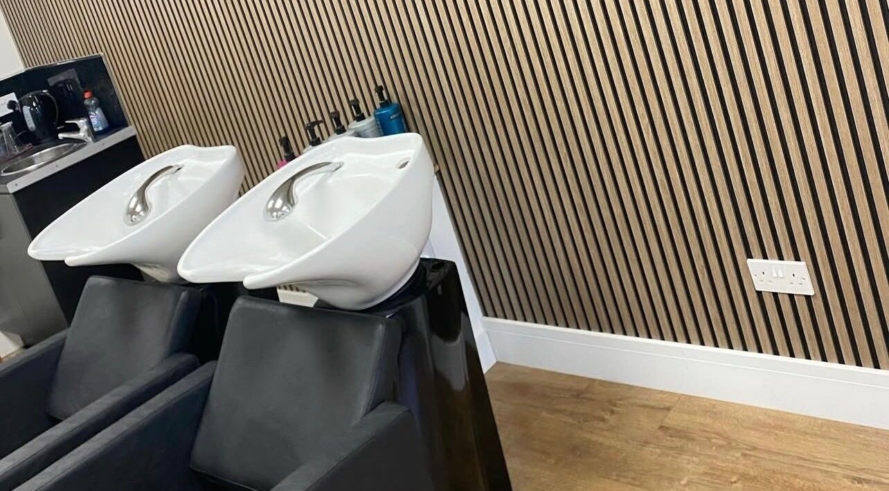 Elegant wash stations at Sarah Howarth hair, Failsworth, England, GB featuring sleek white basins.