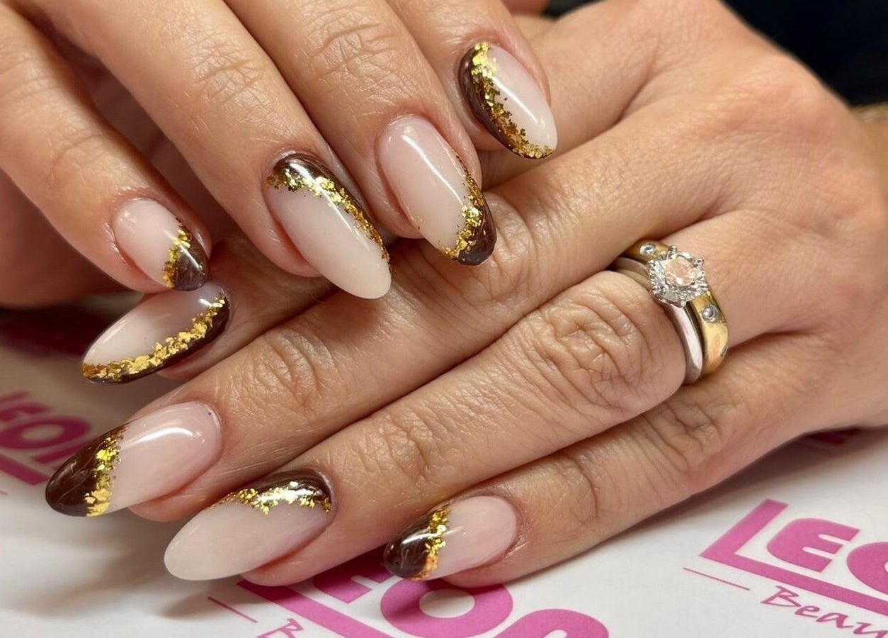 Elegant nail art with gold accents at Leon Beauty in London, GB for a luxurious manicure experience.