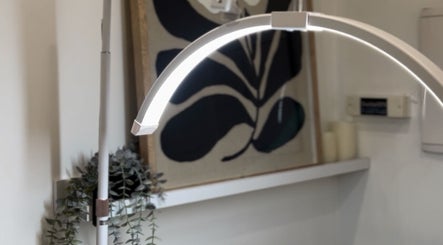 Modern lamp with greenery at Bouttell Beauty, North Lakes, Queensland, AU. Cozy and elegant ambience.