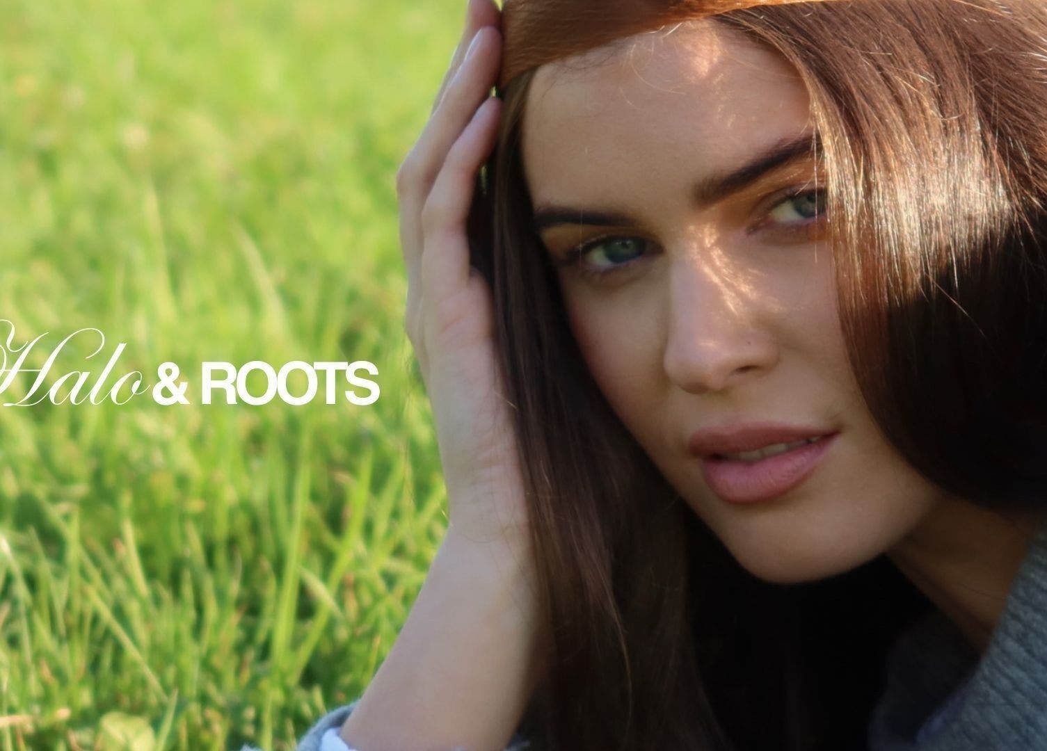 Close-up of a serene woman at Halo & Roots in Kildare, County Kildare, IE with lush green grass background.