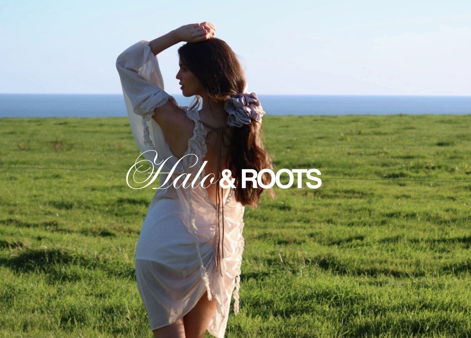Woman in white dress with flower in hair at Halo & Roots, Kildare, County Kildare, IE, overlooking the sea.