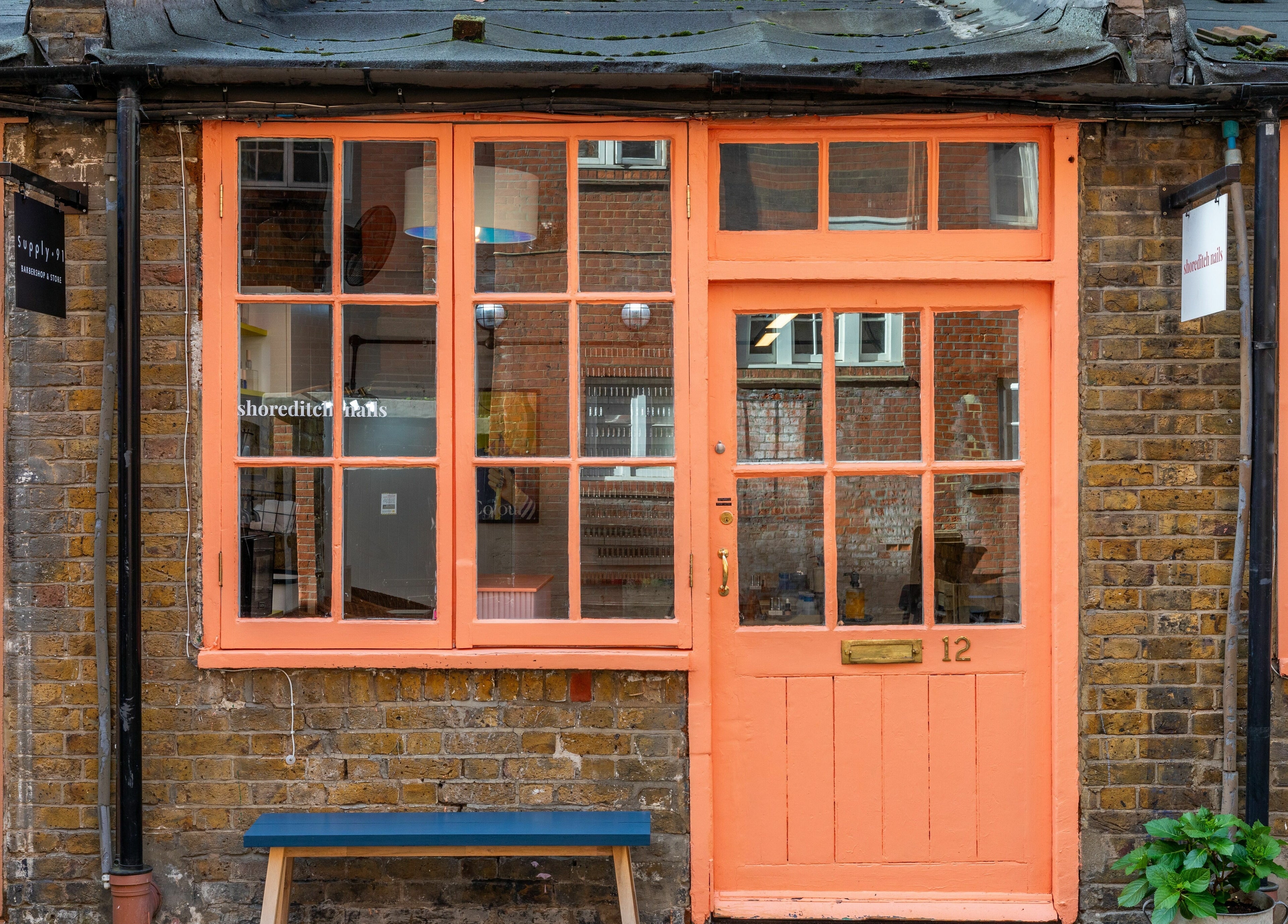 Charming facade of Shoreditch Nails Shoreditch, London, England, GB showcasing its coral-painted entrance.