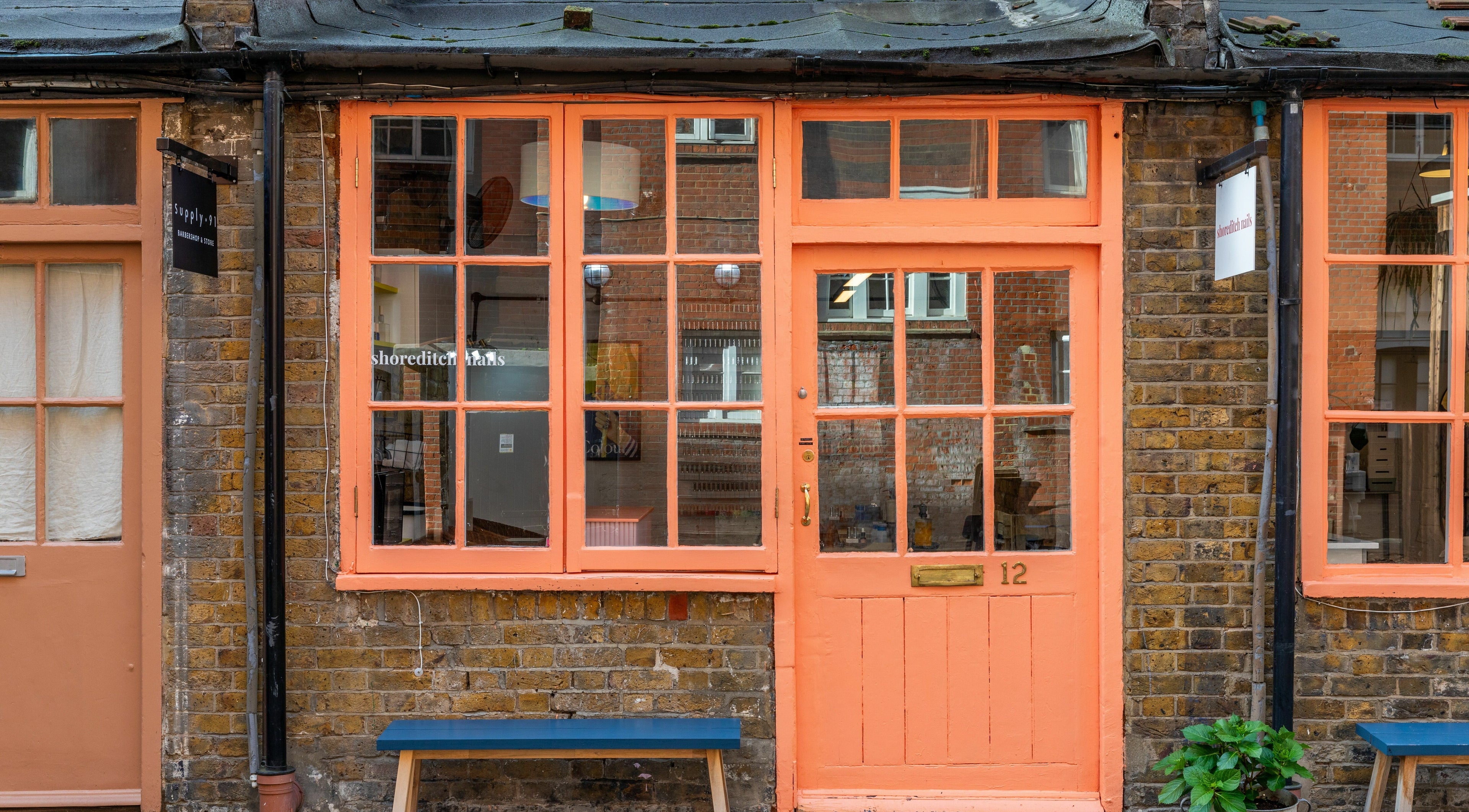 Charming facade of Shoreditch Nails Shoreditch, London, England, GB showcasing its coral-painted entrance.