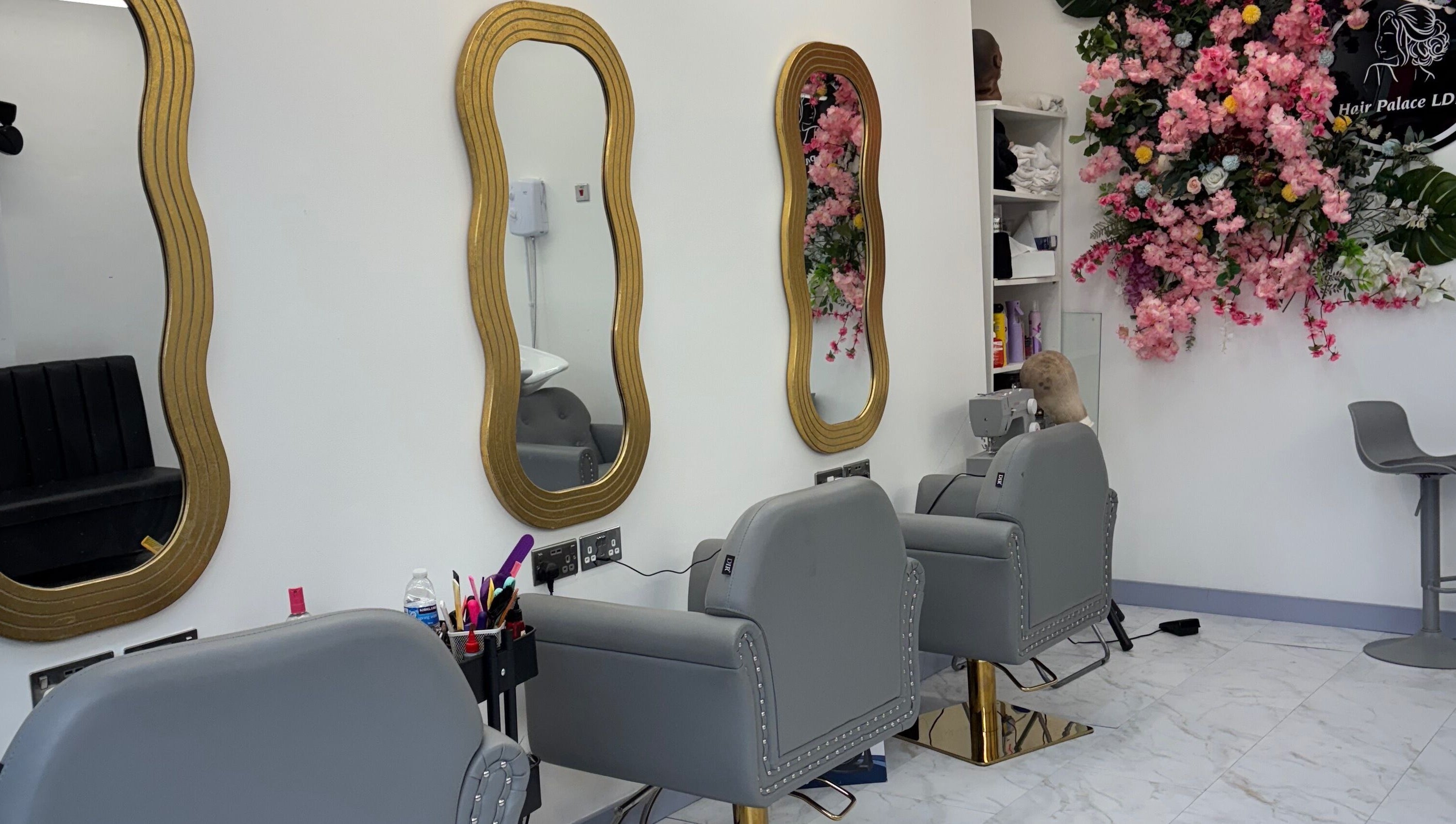 Stylish salon interior at Hair Palace LDN, Peckham rye, England, GB with ornate mirrors and floral decor.
