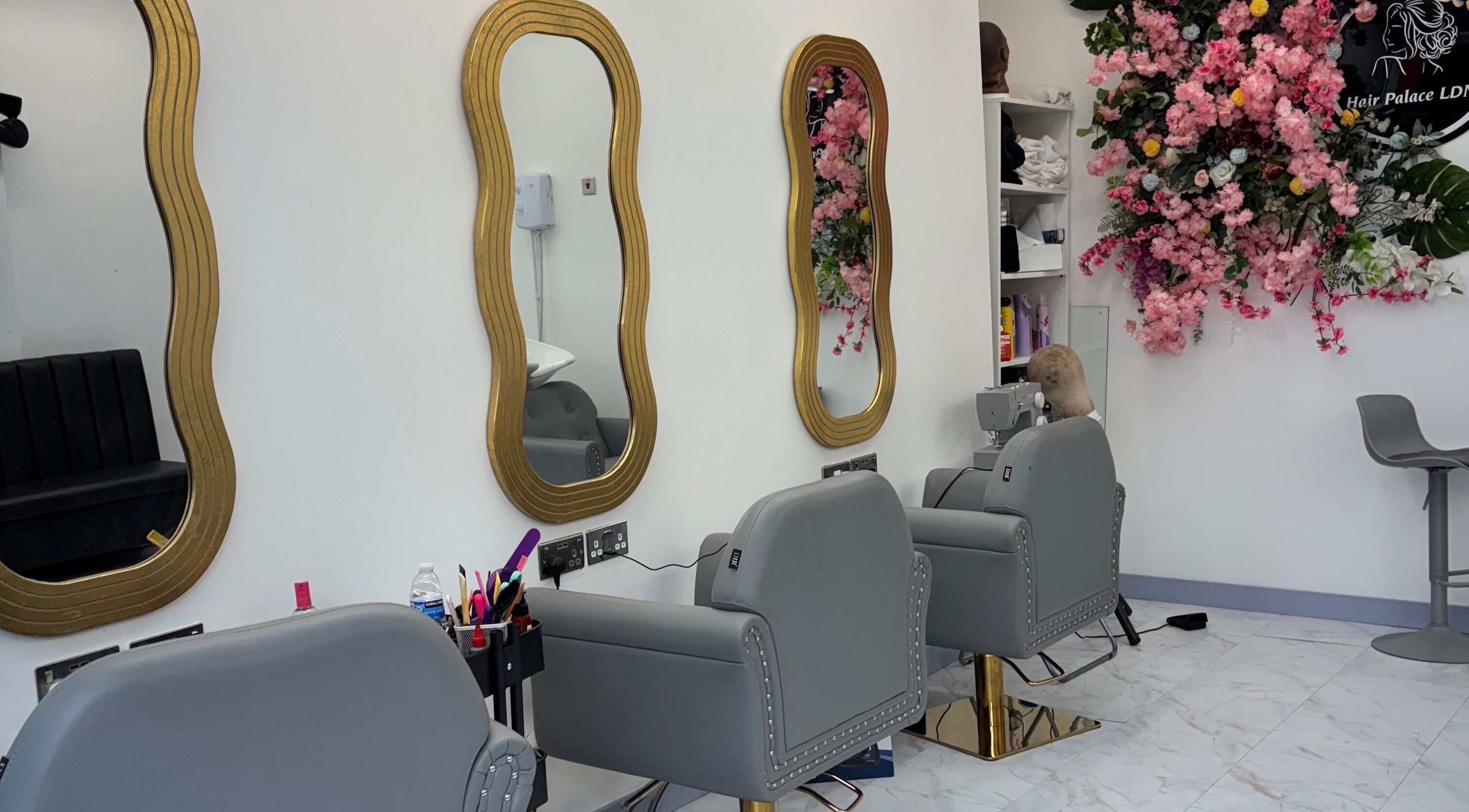 Stylish salon interior at Hair Palace LDN, Peckham rye, England, GB with ornate mirrors and floral decor.