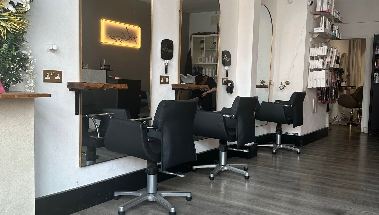 Modern salon chairs and mirrors at Malayage in Nottingham, England, GB, showcasing chic interior design.