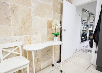 Elegant corner of Alter Ego Hair Design & Cosmetics in Rose Bay, New South Wales, AU with a chic table and chair.
