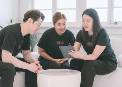 Staff collaboration at Adore Beauty And Wellness, Hawthorne, Queensland, AU in a cozy, light-filled room.