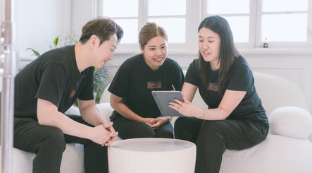 Staff collaboration at Adore Beauty And Wellness, Hawthorne, Queensland, AU in a cozy, light-filled room.