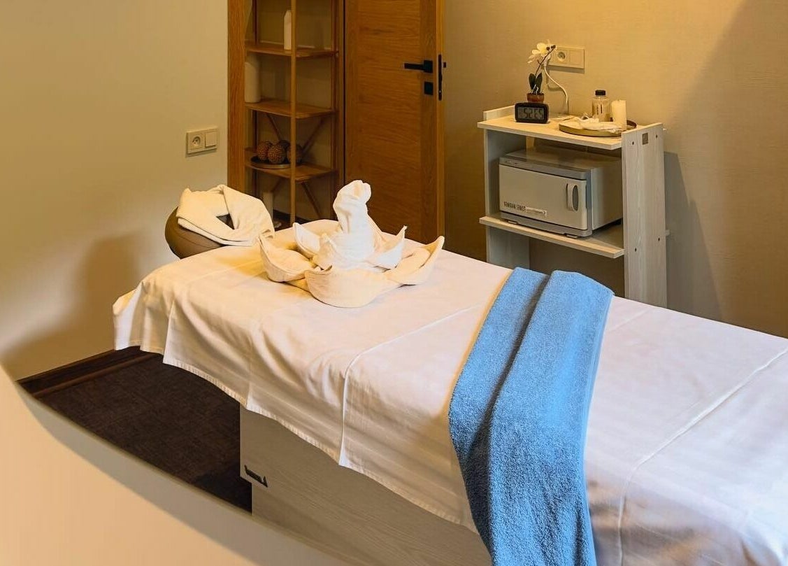 Tranquil massage room at Apricot Spa, Yerevan, AM, featuring a cozy bed with decorative towels.