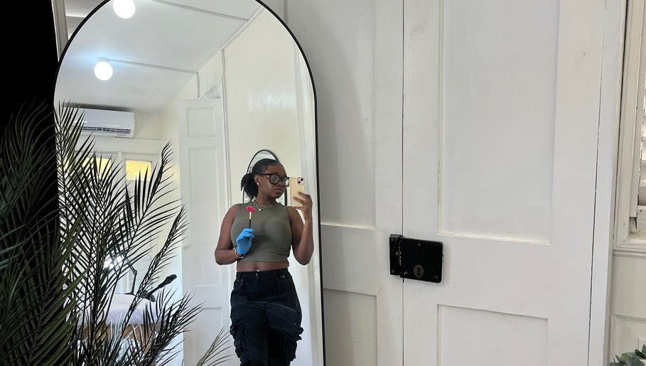 Woman in Waxology Barbados wearing gloves in a serene room at Bridgetown, Saint Michael, BB.