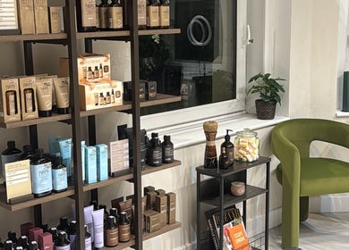 Product display at Megy’s Hair Studio, London, England, GB with a plush green chair.