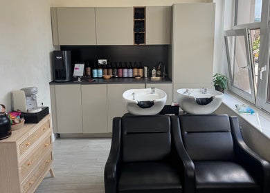 Modern wash stations at Megy’s Hair Studio, London, England, GB with sleek black chairs and cabinetry.