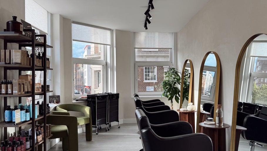 Interior of Megy’s Hair Studio in London, England, GB with modern chairs and mirrors.