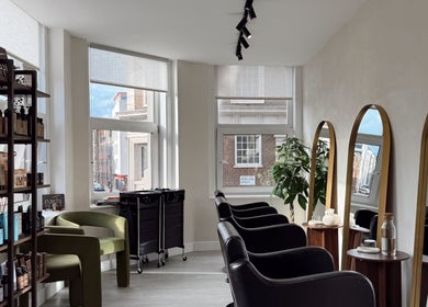 Interior of Megy’s Hair Studio in London, England, GB with modern chairs and mirrors.