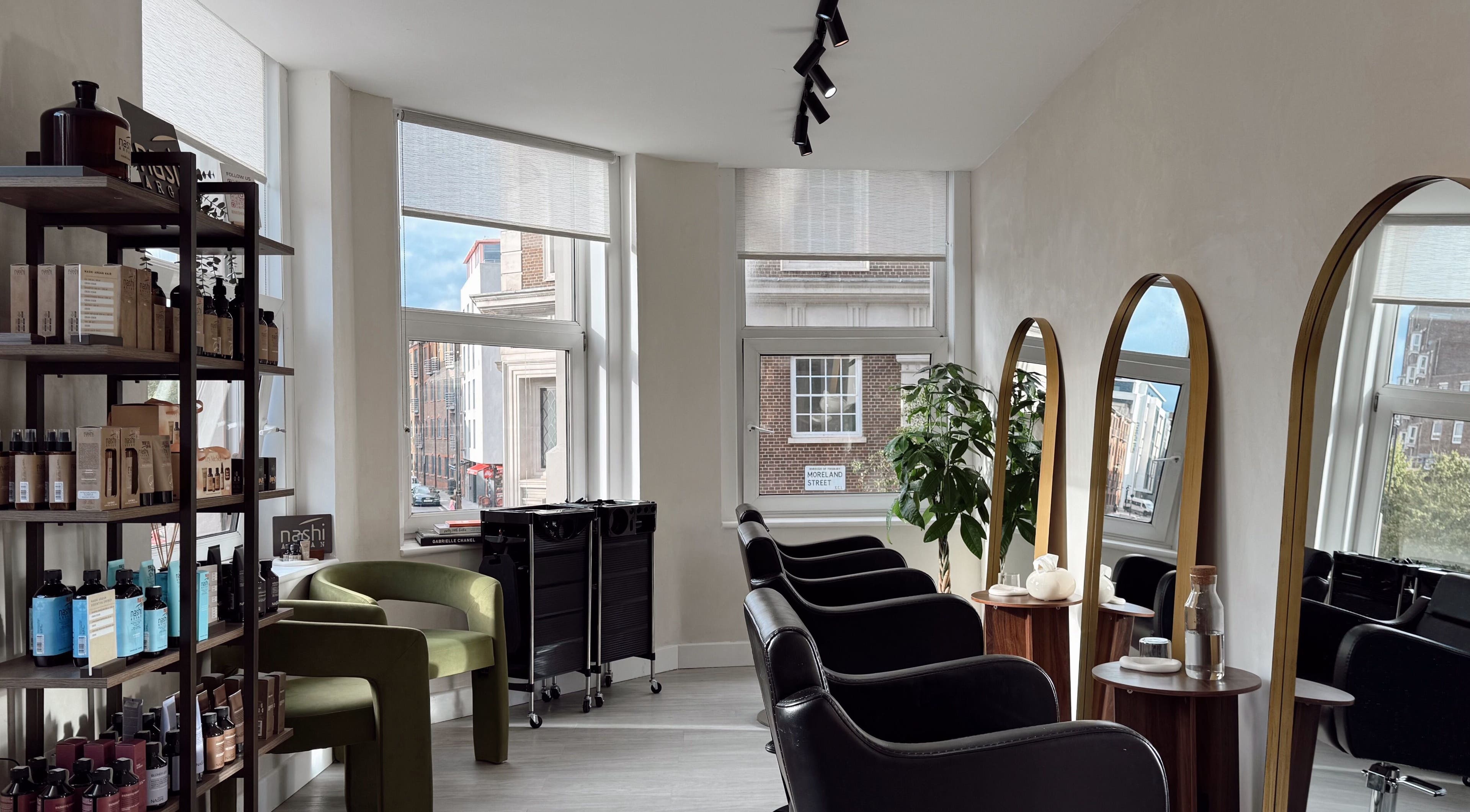 Interior of Megy’s Hair Studio in London, England, GB with modern chairs and mirrors.