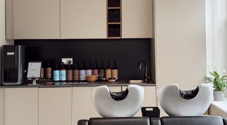 Modern washing station at Megy’s Hair Studio, London, England, GB, featuring sleek sink and premium products.
