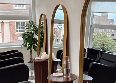 Chic interior of Megy’s Hair Studio in London, England, GB featuring elegant mirrors and comfortable chairs.