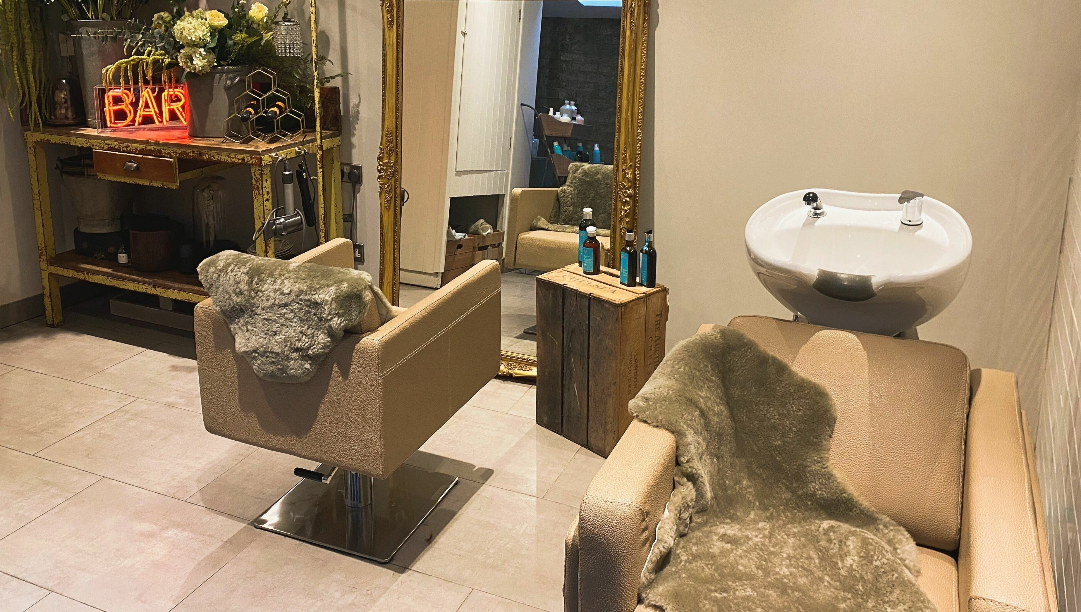 Elegant salon interior at Aimee-Blu, London, England, GB with plush styling chairs and rustic decor.